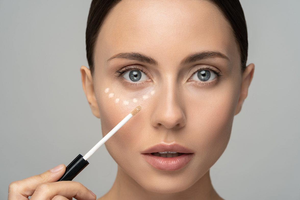 Portrait of a Woman Applying Concealer Under Her Eyes 